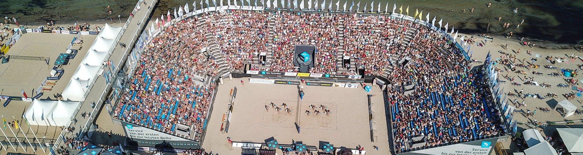 Luftaufnahme eines gefüllten Stadions am Strand