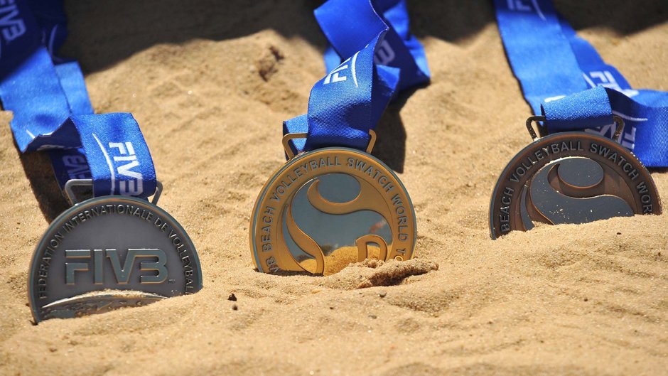 Medaillen liegen im Sand